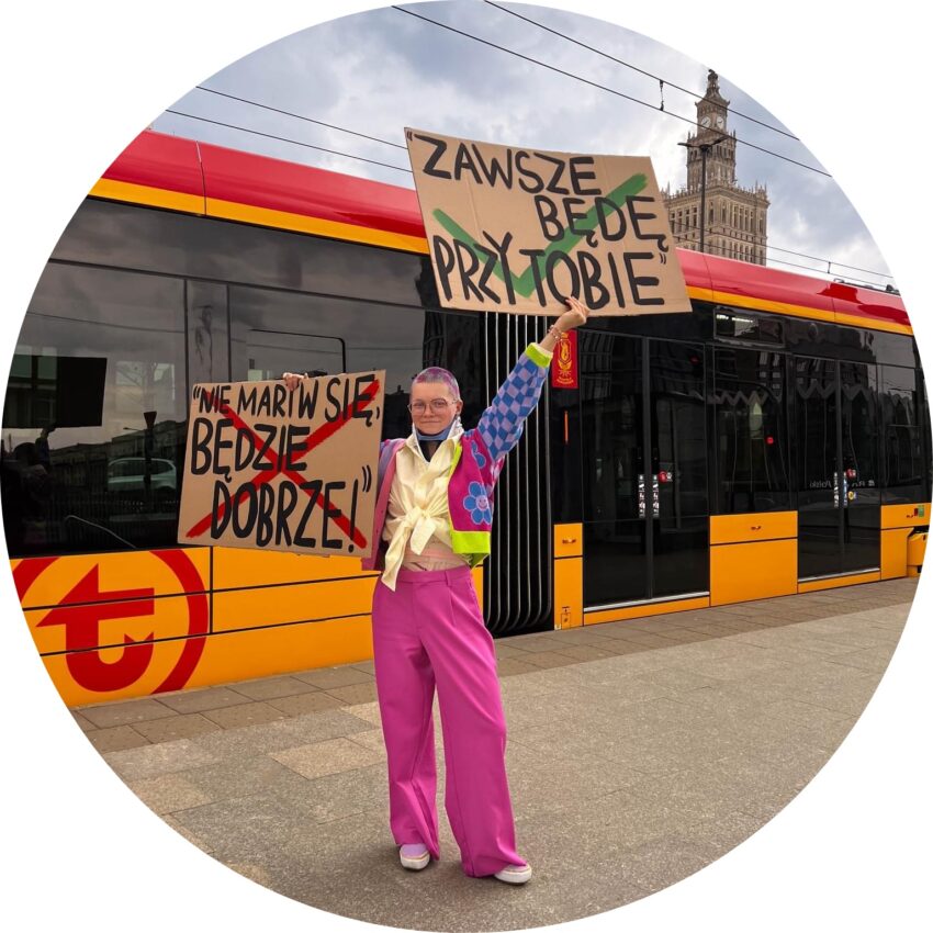 Małgorzata Sajan z transparentami przed tramwajem