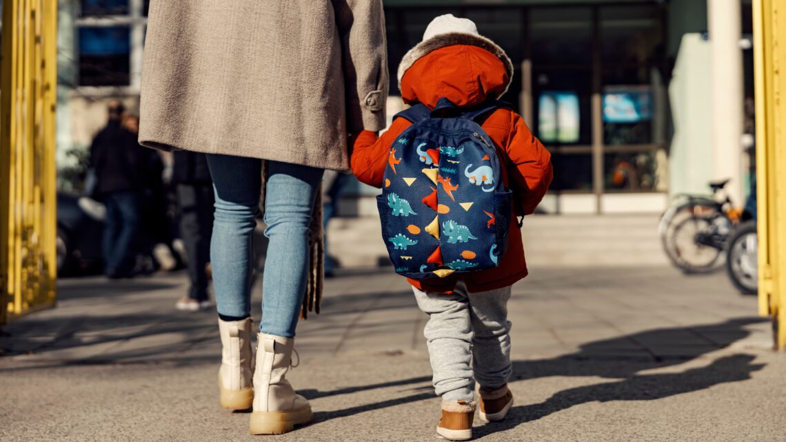 Mama odprowadzająca dziecko do przedszkola (tyłem)- Hello Zdrowie