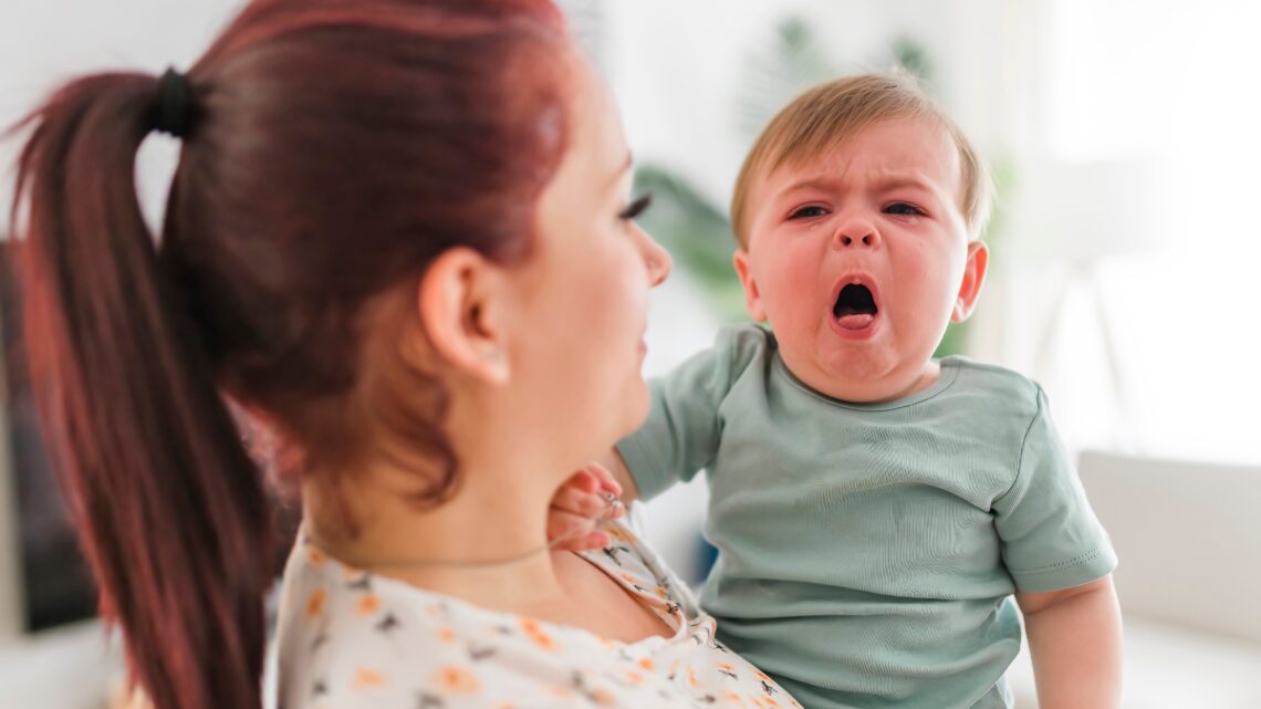 mama trzyma na rękach kaszlące dziecko - Hello Zdrowie