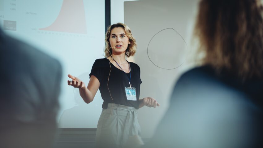 kobieta daje wykład podczas konferencji - Hello Zdrowie