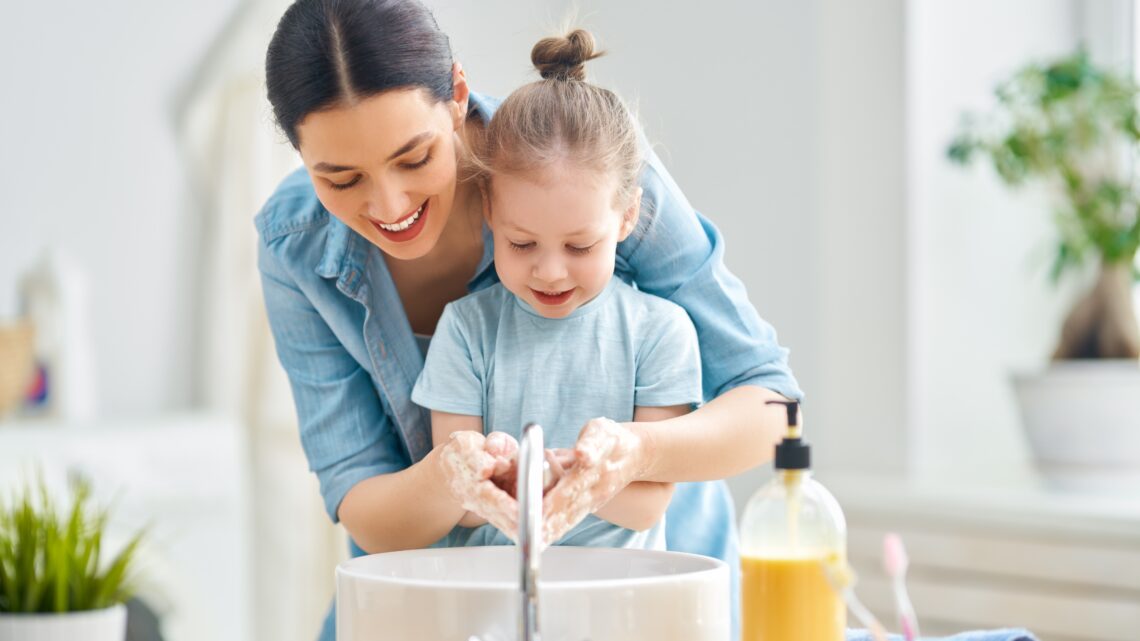 Mama prowadzi dłonie córki, wspierając jej ruchy podczas codziennej czynności. Takie prowadzenie rąk to kluczowy element metody Affolter, pomagającej w rozwijaniu percepcji i orientacji w przestrzeni poprzez doświadczenia dotykowe.