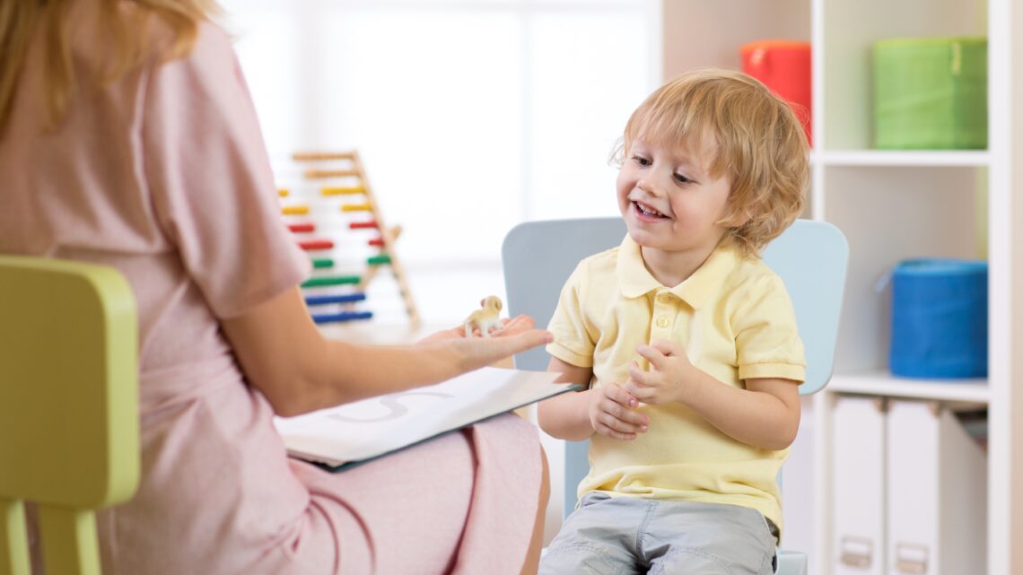 Psycholog dziecięcy obserwuje zachowanie dziecka. Spotkanie jest częścią badania ADOS-2, służącego do diagnozy autyzmu poprzez ocenę komunikacji i interakcji społecznych.