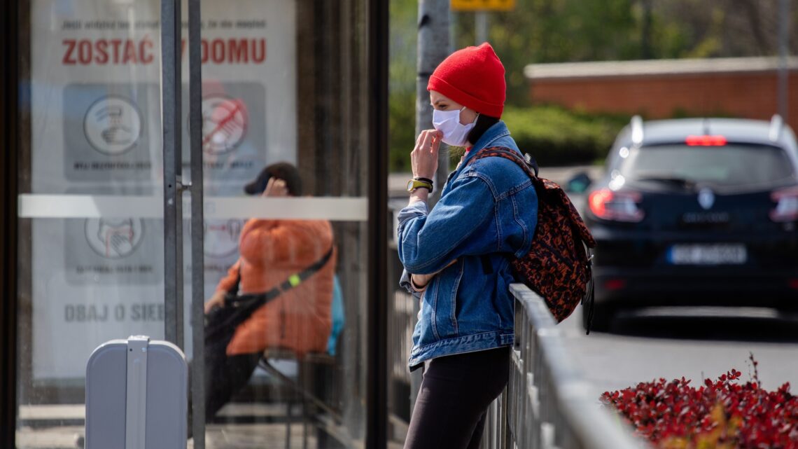 na zdjęciu: kobieta na przystanku w czasie pandemii, tekst o długofalowych skutkach pandemii - Hello Zdrowie